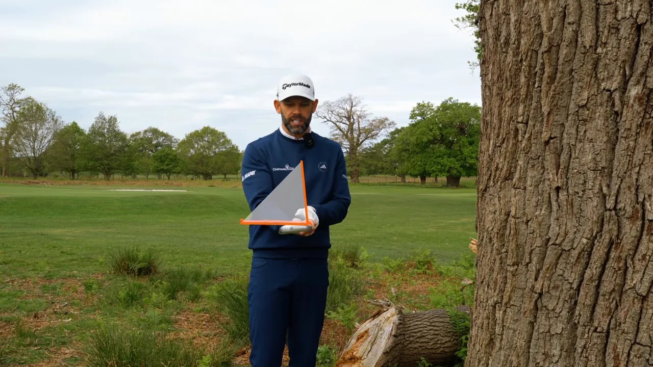 Golf instructor demonstrates how the clubface rotates using an orange alignment marker on the club