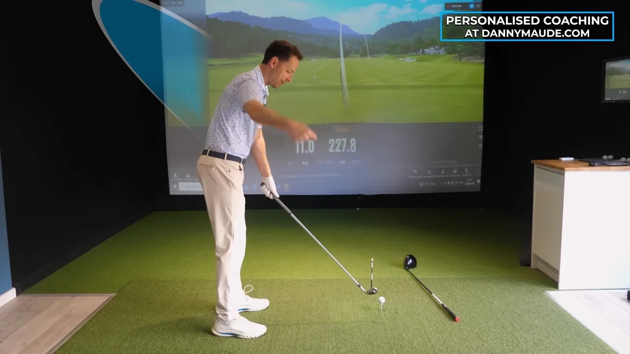 Golf coach with simulator guidance lines emphasizing clubface-to-swing-path mismatch