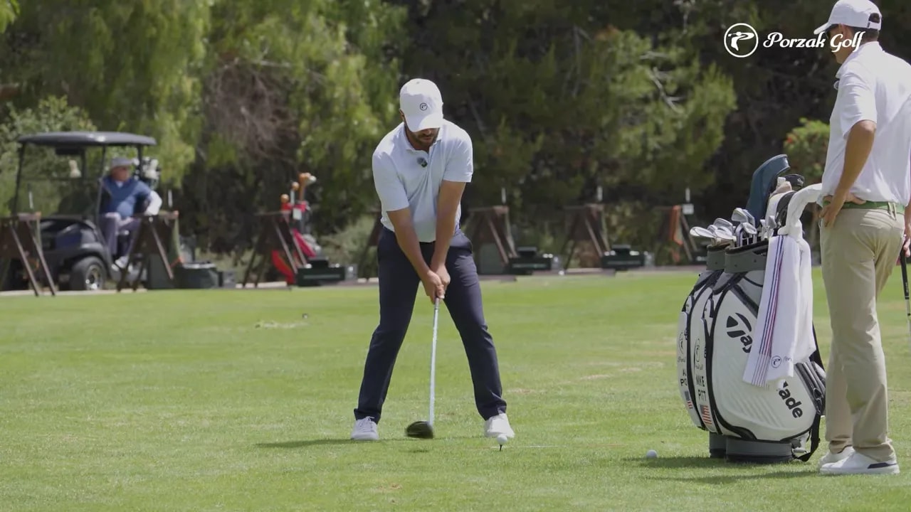 Golfer in early backswing with hands and club moving toward the set position during driver vs iron takeaway lesson