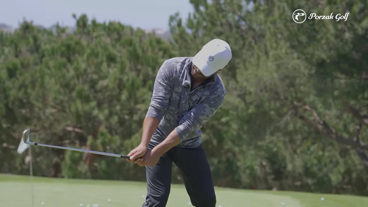 Golfer holding a club parallel checkpoint in the early takeaway to demonstrate connected, on-plane motion