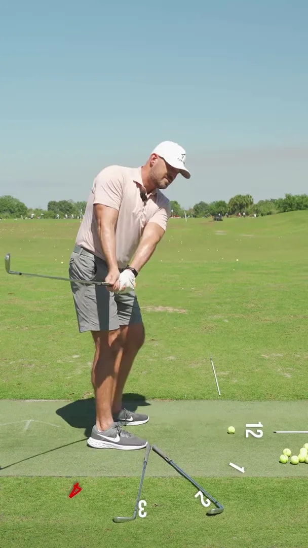 Golfer showing early takeaway path with markers to correct inside takeaway and feel 2 o’clock direction