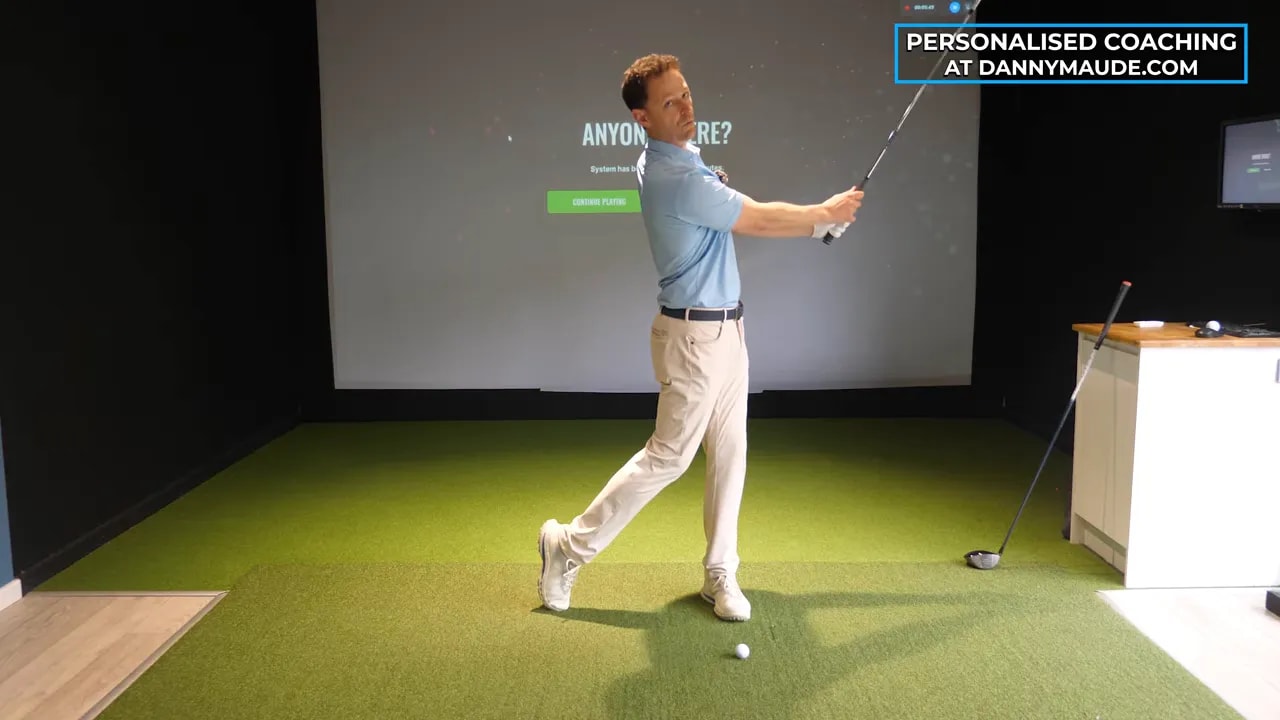 Clear side view of golfer practicing the educated hands golf swing backswing lever drill