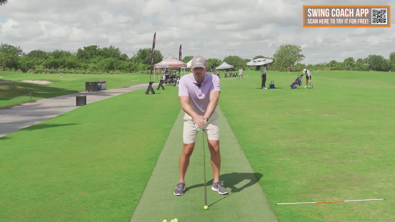 Golfer front-on demonstrating trail knee and lower-body position during a downswing drill