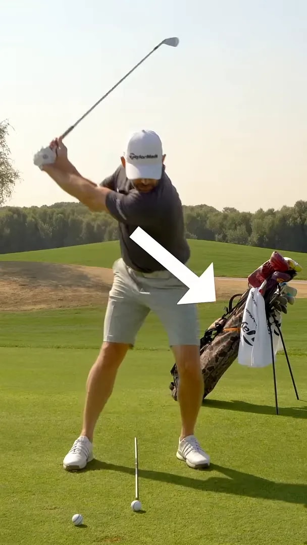 Golfer pointing to the lead-foot lift-and-fall moment that triggers the golf downswing