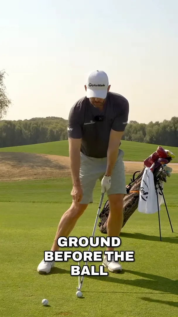 Golfer demonstrating keeping the club from hitting the ground before the ball in the downswing