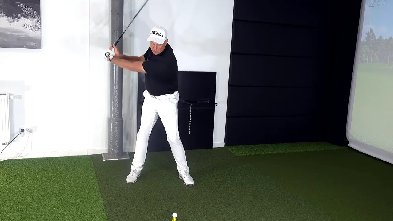 Golf swing drill showing the right side lowering into the downswing