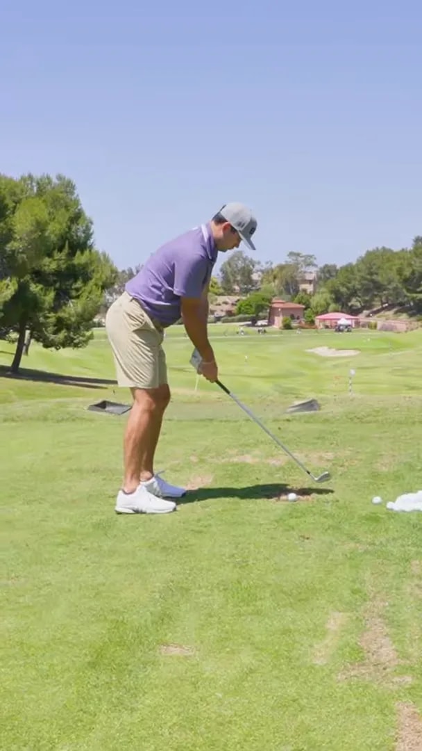 Golfer set up at address on a golf course with the ball on the ground