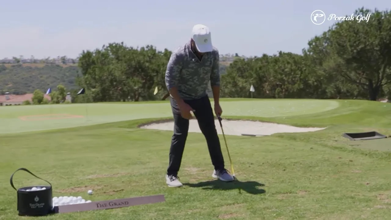 Golfer preparing at address on a range with a teed ball in front