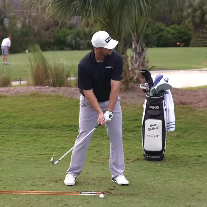 Golfer practicing controlled shot shape using alignment rods on the range