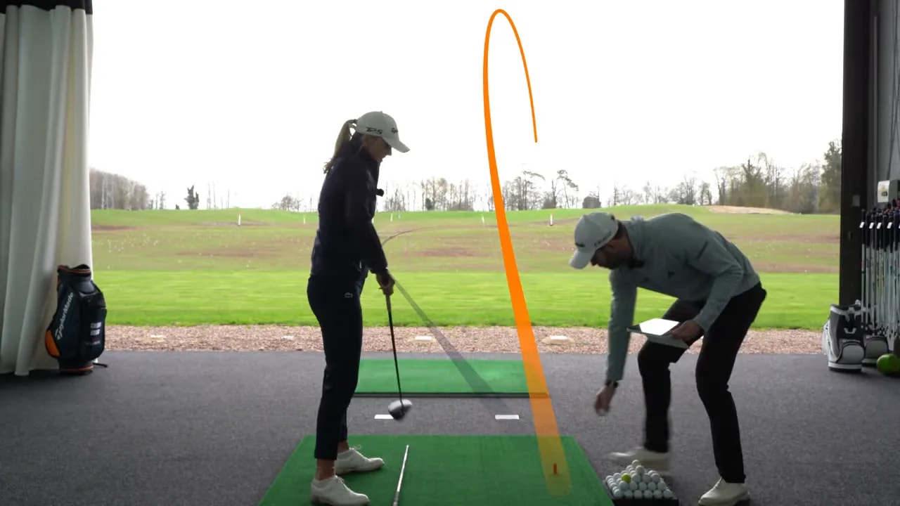 Golfer checking driver alignment and swing path on simulator mat with alignment markings