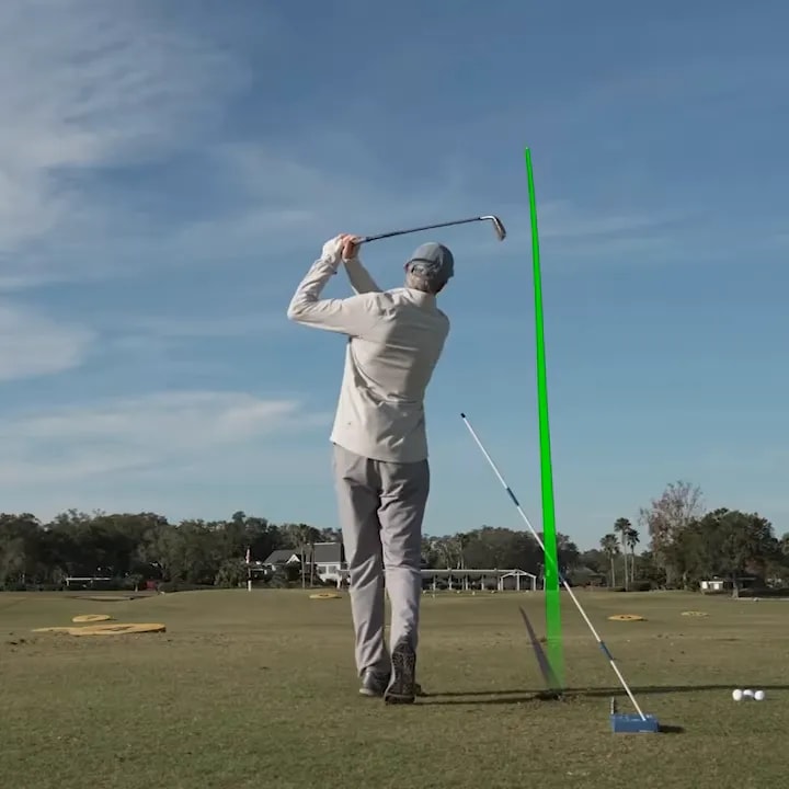 Golfer demonstrating driver swing with an obstacle alignment guide for inside path and upward strike