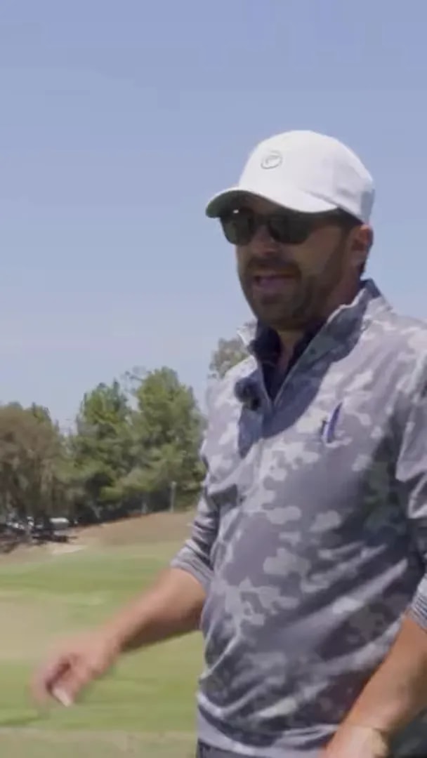 Golfer speaking on a golf range about full swing versus knockdown trajectory control