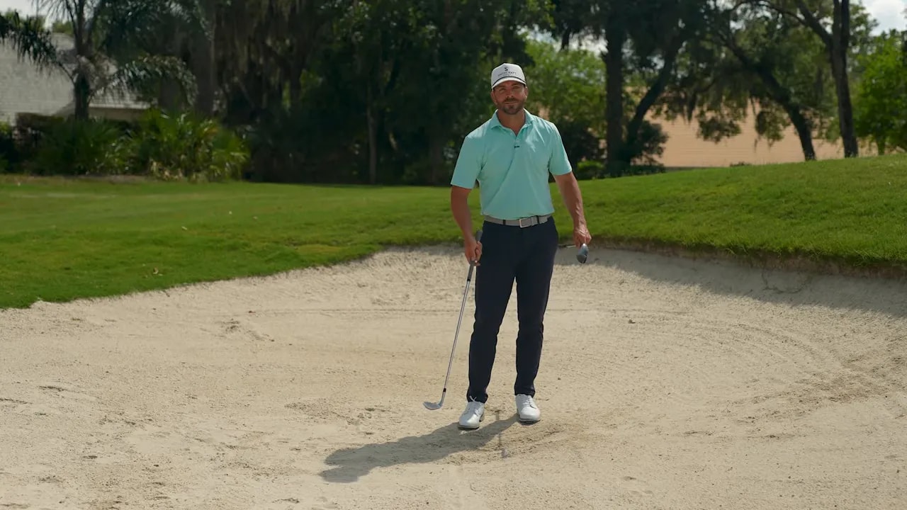 Golfer in greenside bunker holding a wedge while discussing bounce and forgiveness