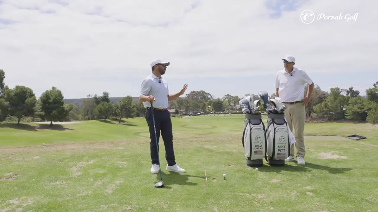 Instructor and golfer discussing on the range next to golf bags for driver takeaway vs iron takeaway feel difference