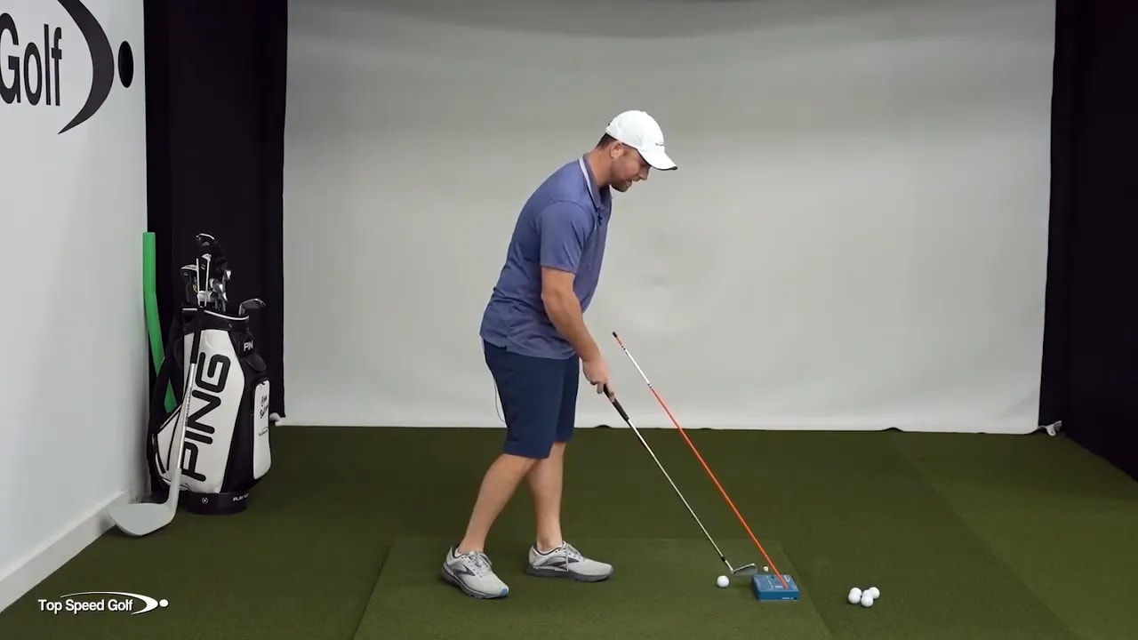 Golf drill showing maintaining posture and moving hips back while practicing downswing with training block