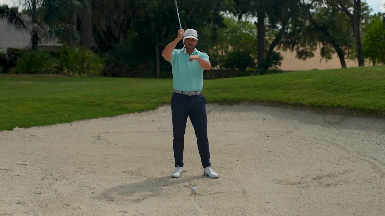 Golfer demonstrating open-face bunker setup to encourage bounce