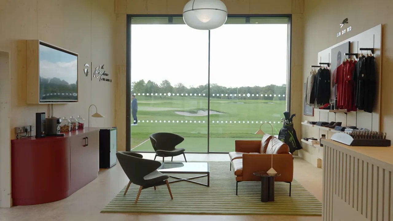 Player lounge seating inside TaylorMade Kingdom at The Grove with floor-to-ceiling range view
