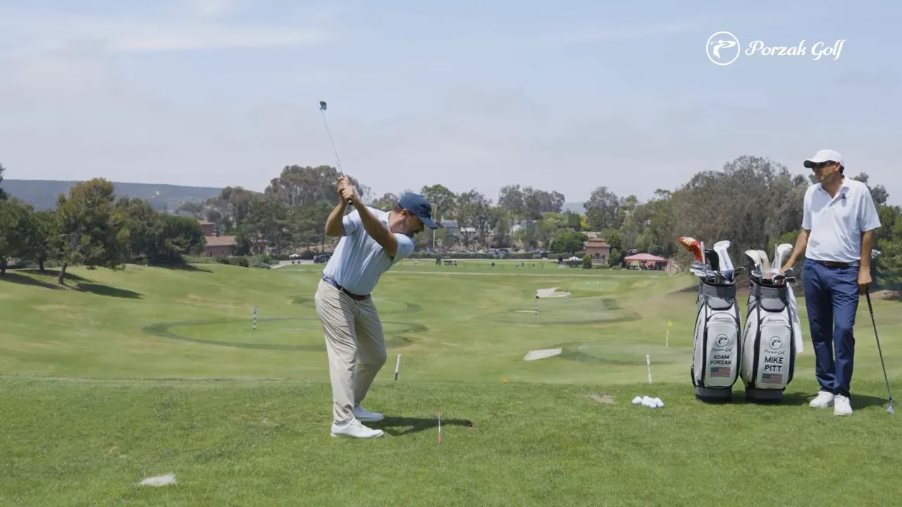 golfer holding a club near the top of the backswing on a driving range