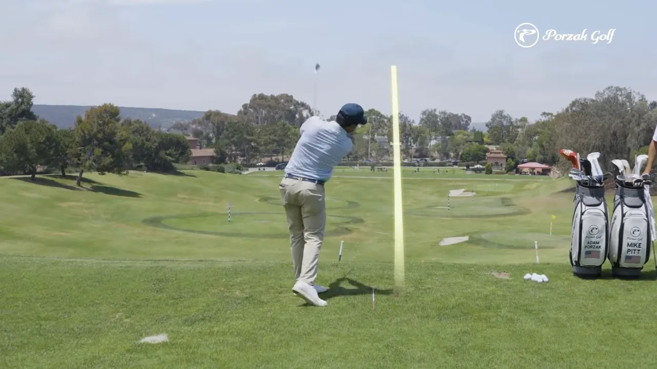 golfer finishing an iron shot with a bright shot tracer rising into the sky
