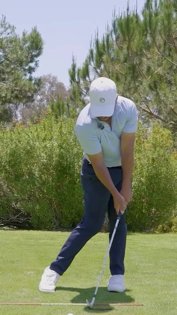 front view of downswing with club near impact and trail foot pressure still braced inside