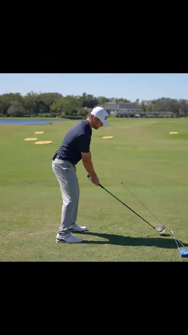 golfer at address on a driving range with alignment guides on the ground