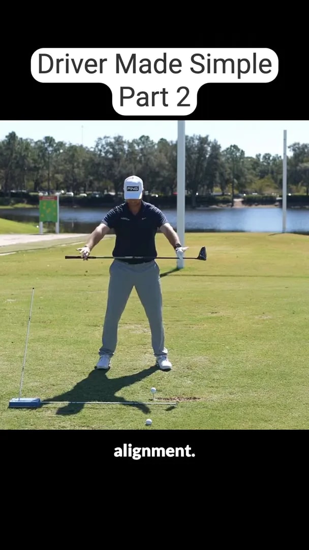 golfer standing square with an alignment stick on the grass and club held across the body