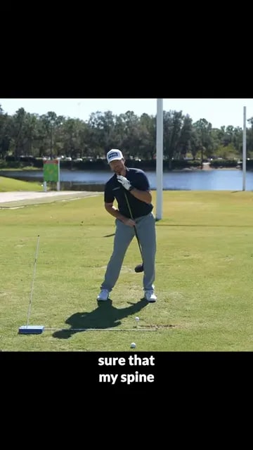 golfer at address showing spine tilted slightly away from target with club held against body
