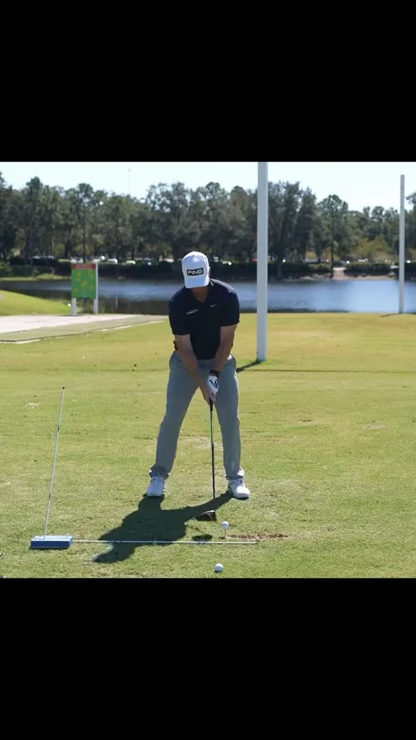 golfer bent into setup while demonstrating upper body tilt beside a driver