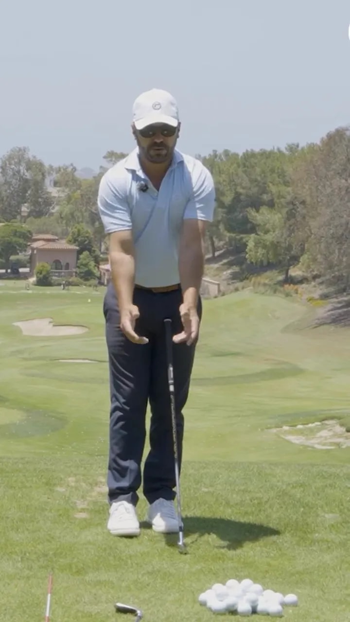 golfer standing face-on with forearms and hands held forward to demonstrate arm and elbow position