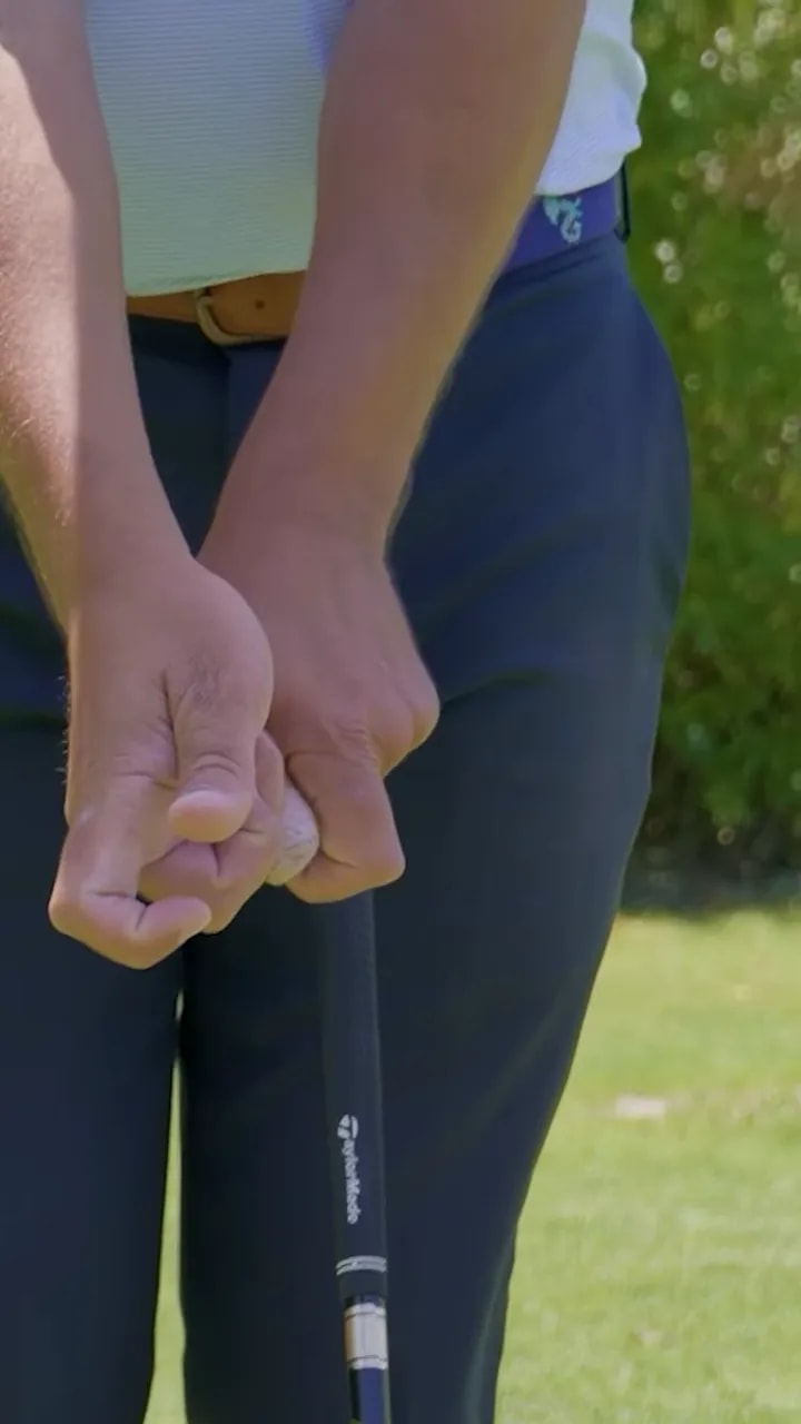 close view of both hands on the golf club grip with the hands brought together