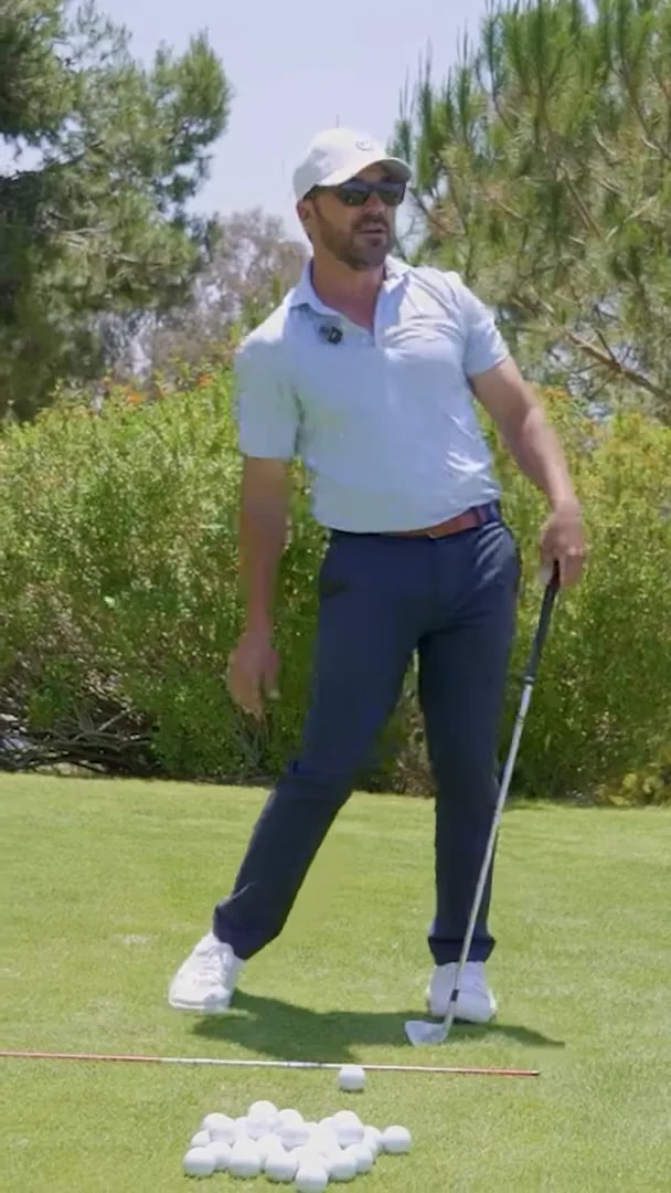 side view of golfer at address on practice fairway with ball on grass