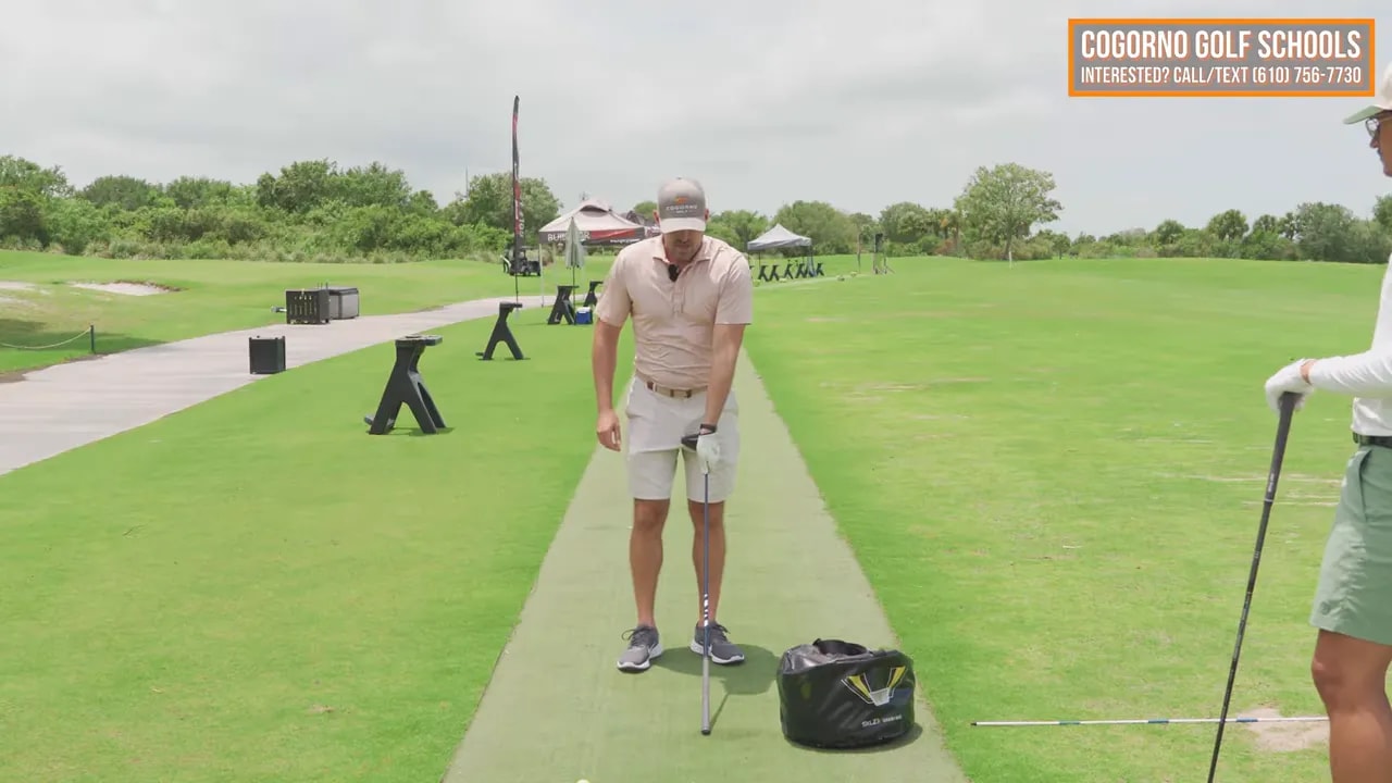 Golfer demonstrating upside down club drill into impact bag with text saying get the grip into the bag with some speed