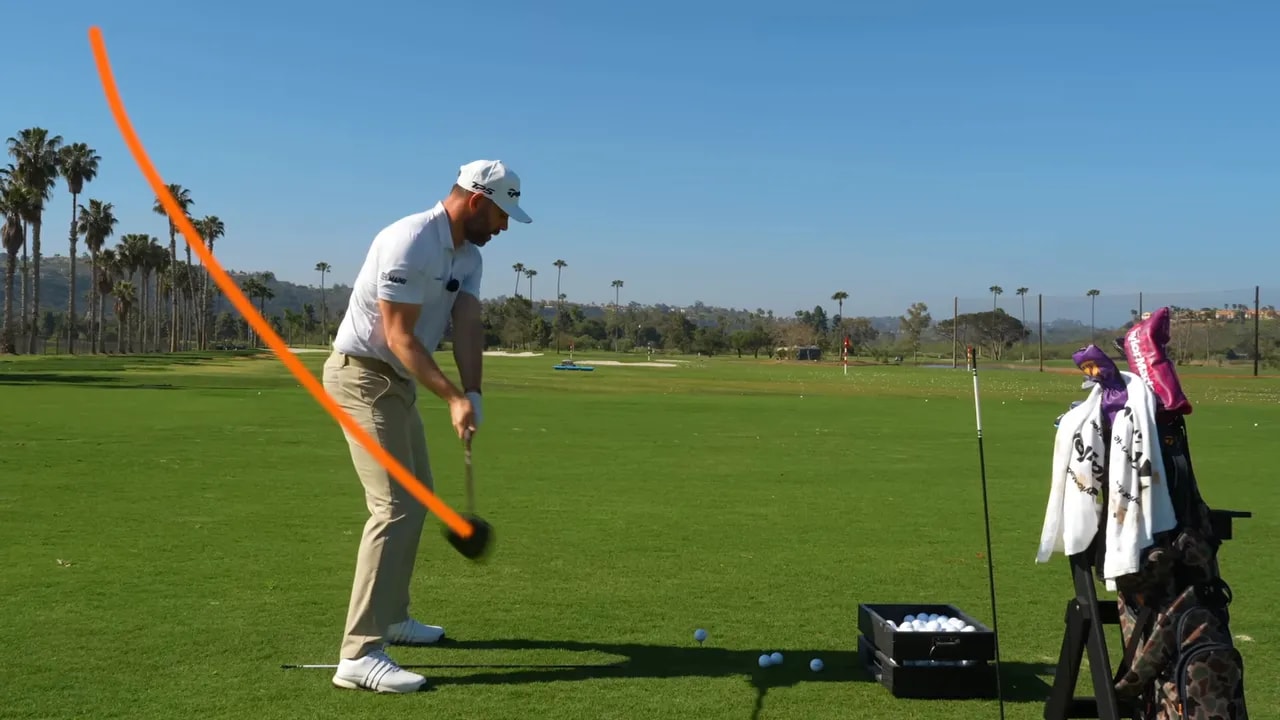 Golfer mid-downswing with curved orange swing path and green check mark