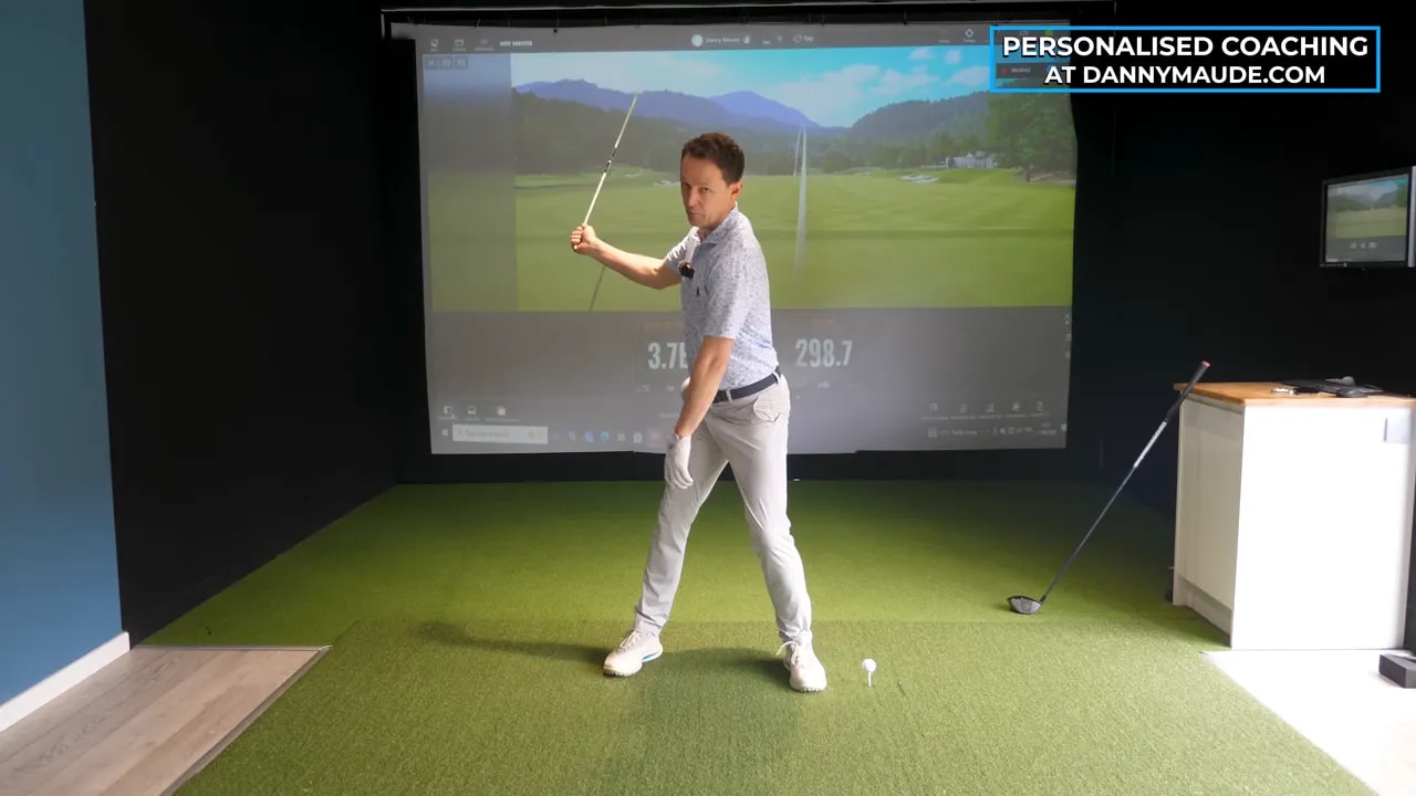 Golfer standing side on with lead arm raised and bent to demonstrate arm position