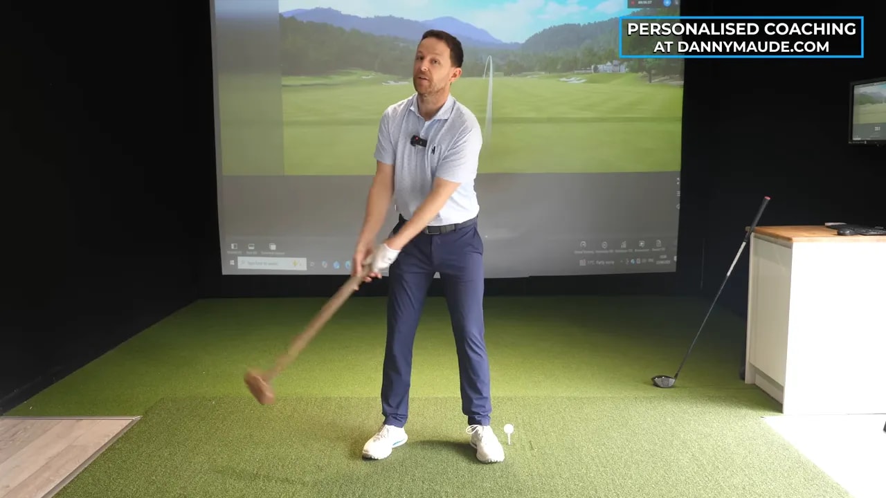 golfer swinging a sledgehammer indoors to demonstrate weighted motion