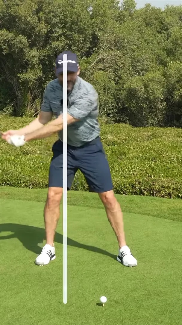 Golfer in takeaway position with a white vertical line overlay showing body position