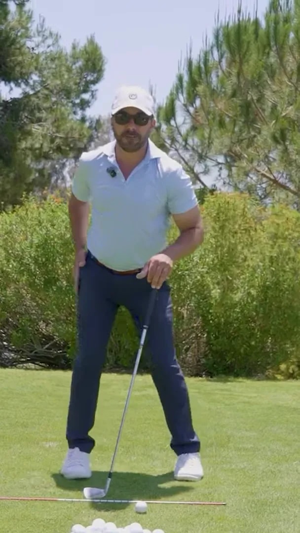 golfer standing over ball with body shifted toward trail side while demonstrating position