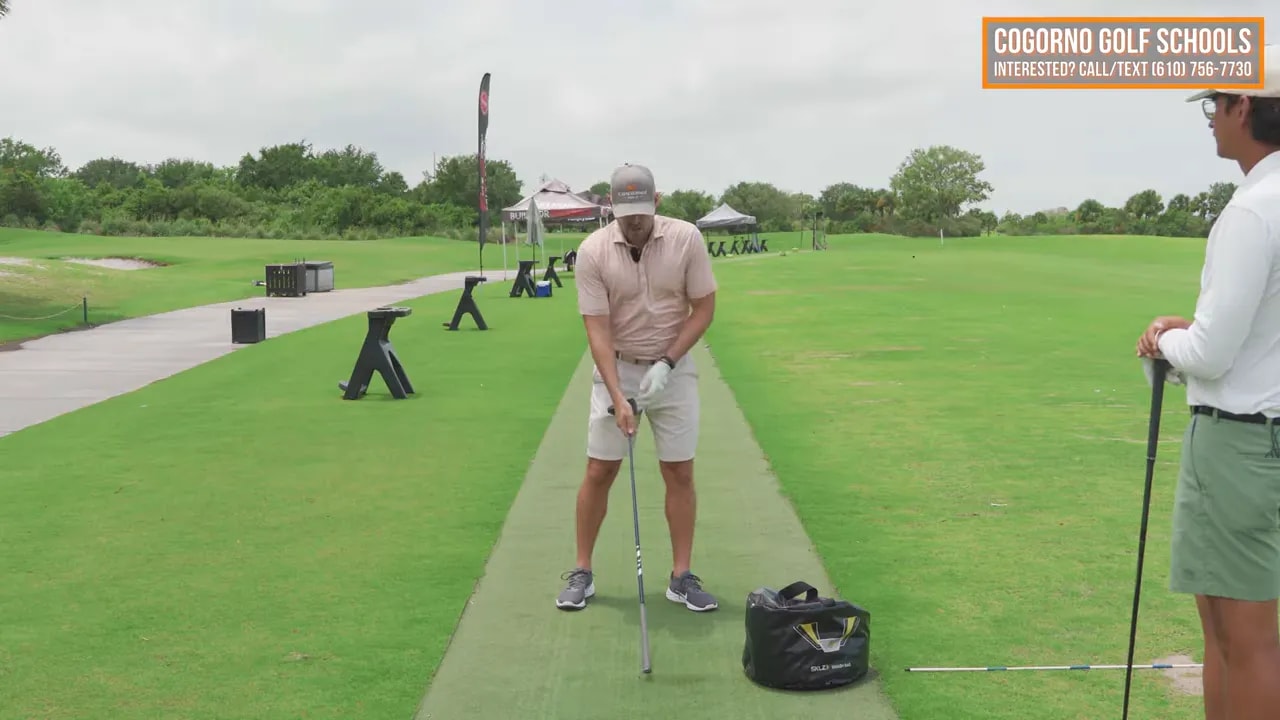 Close view of golfer at address with on screen text that says wrist motion works up and down