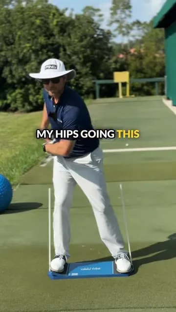 golfer on blue board turning in backswing between two upright guide sticks