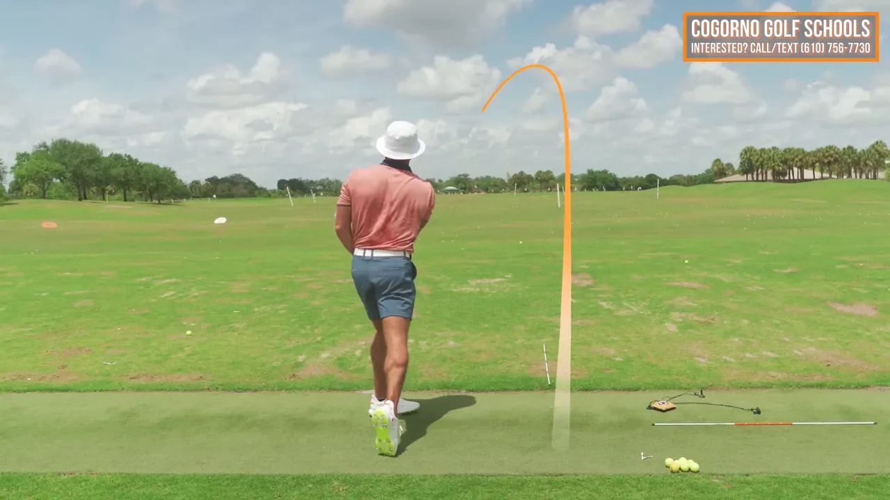 Driver swing finish with ball flight tracer curving left of the target line