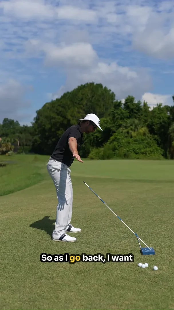 golfer in driver posture with an angled shaft guide on the ground