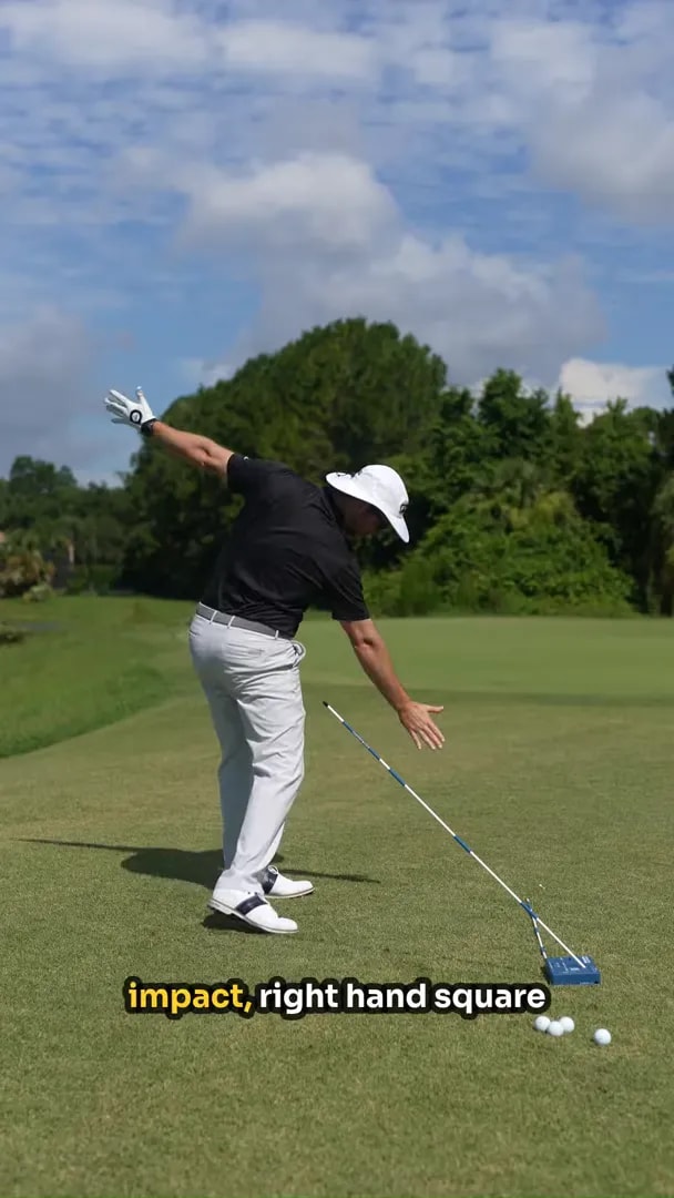 golfer demonstrating through-swing hand position beside the angled shaft guide