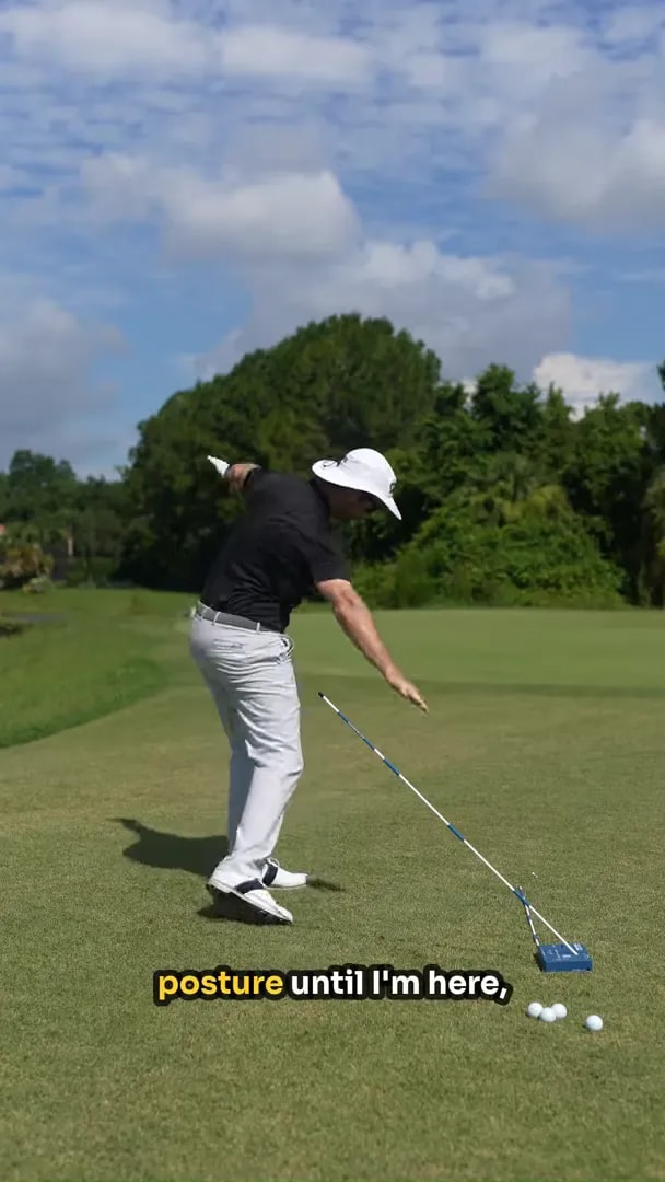 golfer rotating through while maintaining posture beside an angled shaft guide