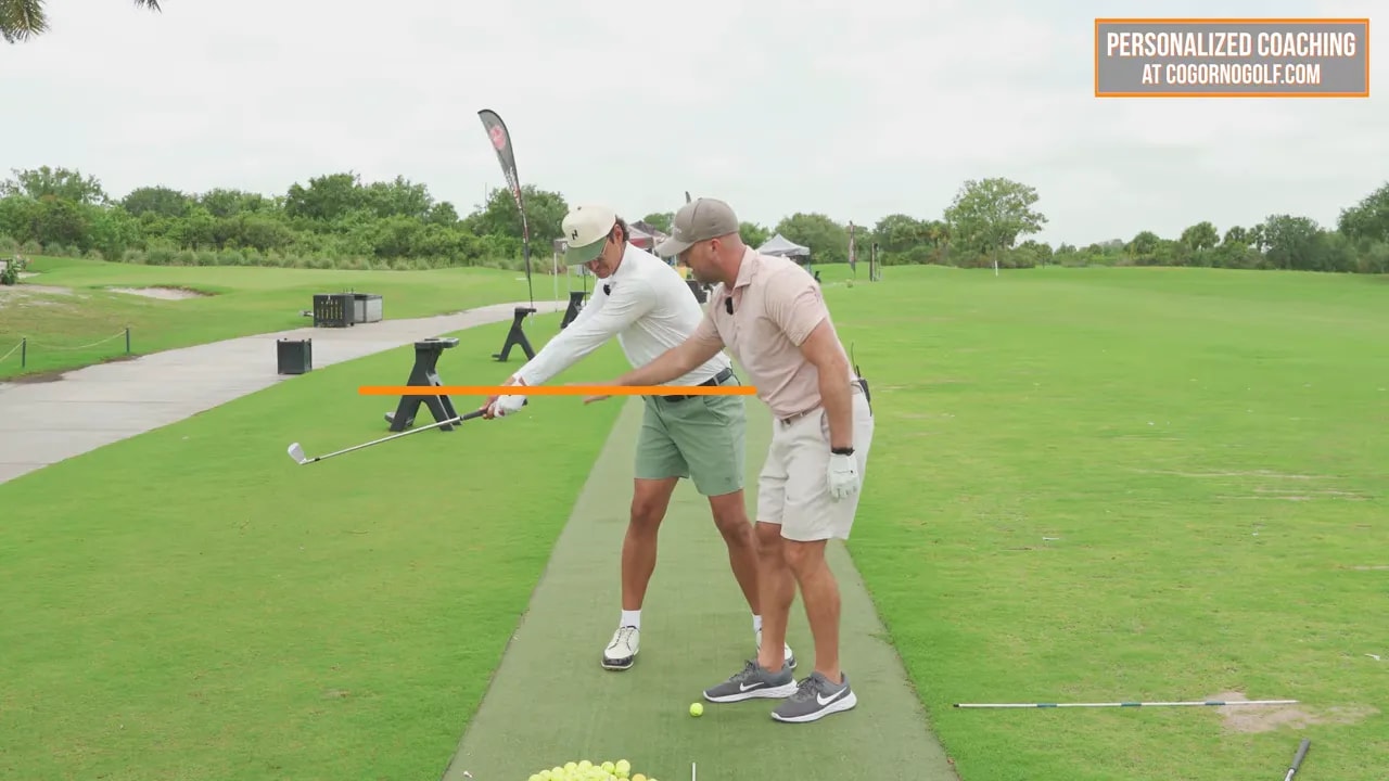 golfer paused in takeaway with arms extended low and an x mark highlighting the incorrect low position