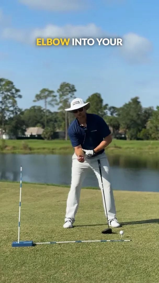 golfer demonstrating right elbow tucked inward near right hip at setup area