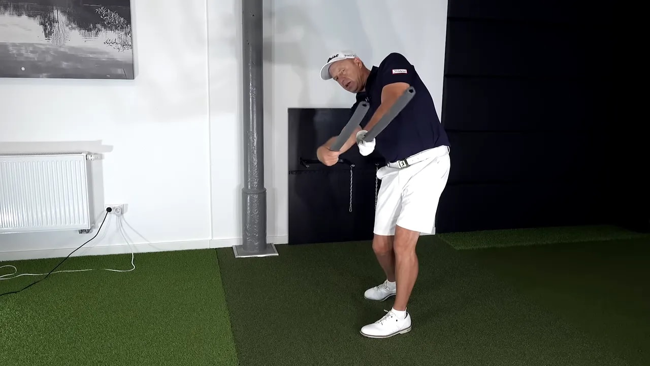 instructor demonstrating club motion with yellow text reading thumbs