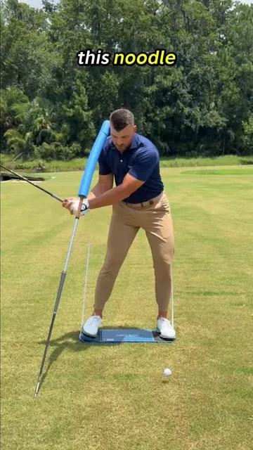 Golfer shifting forward while keeping left ear near blue foam alignment guide