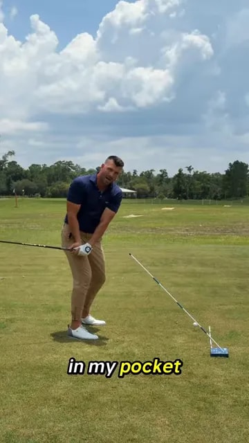 Golfer demonstrating hands moving down toward the trail pocket