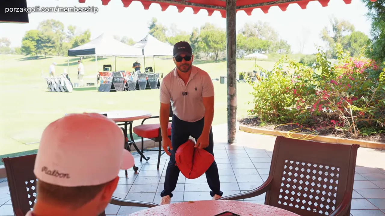 Golfer holding a red cushion between the legs in an athletic stance