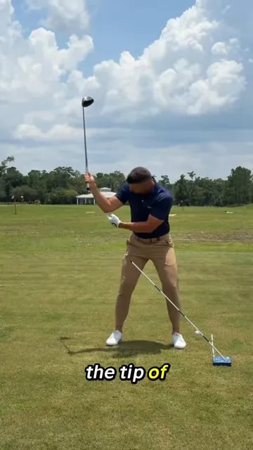 Golfer at the top of the backswing showing space between right elbow and side